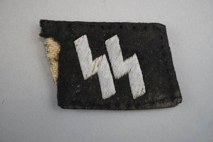 A black patch with white lightning bolt

Description automatically generated