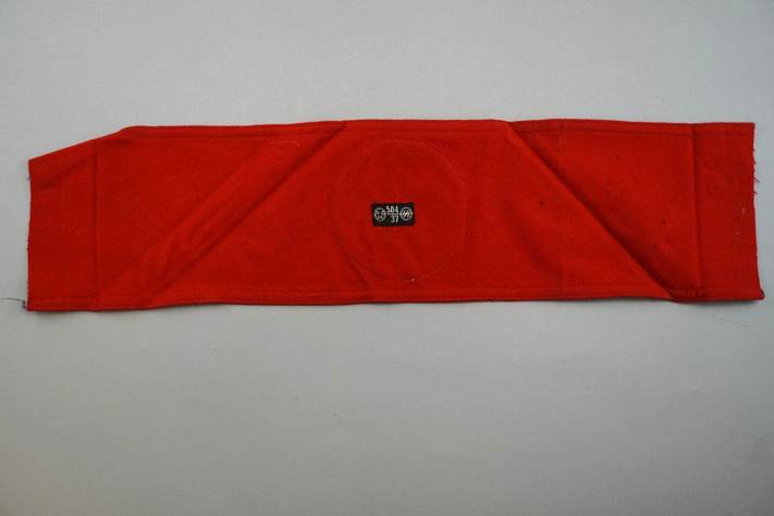 A red cloth with a black logo

Description automatically generated