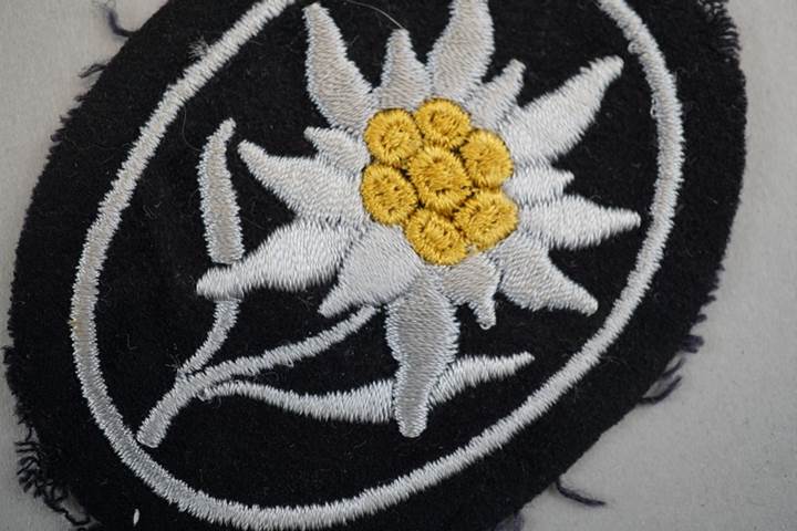 A black and white flower embroidered on a black and white fabric

Description automatically generated