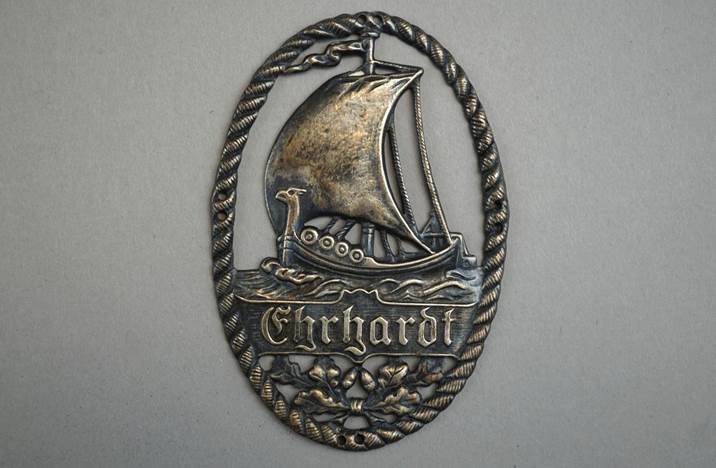 A metal plaque with a boat and text

Description automatically generated