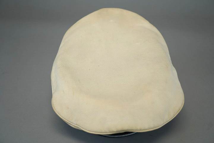 A white cap on a gray background

Description automatically generated