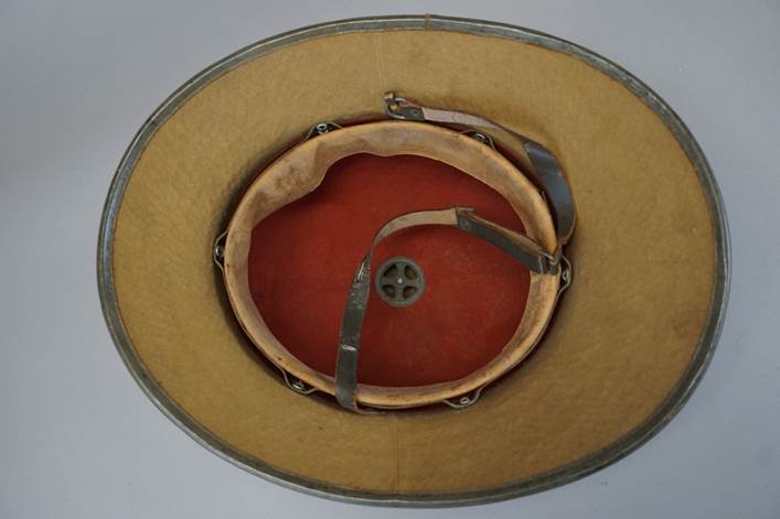 A brown hat with a leather strap

Description automatically generated