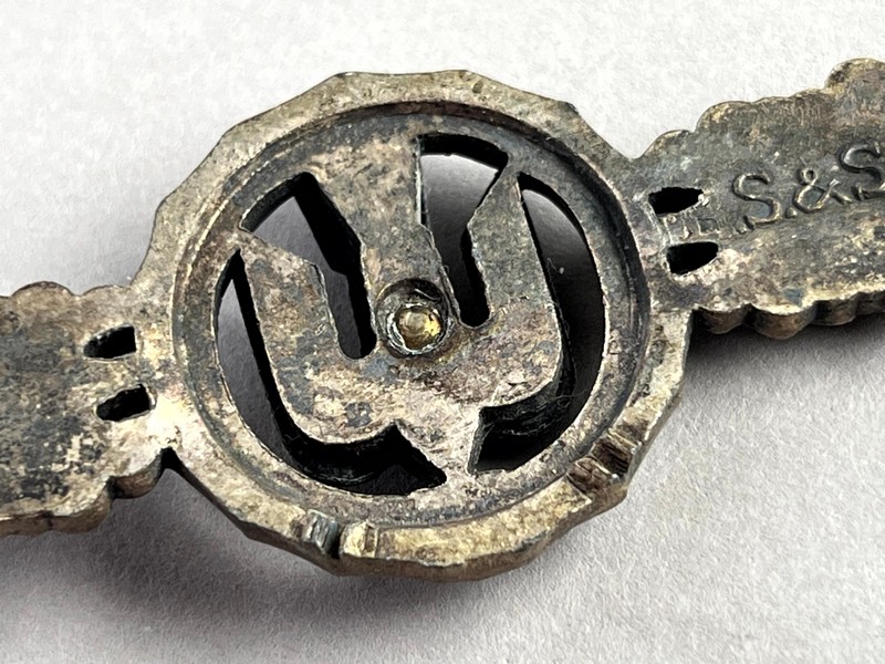 A close-up of a metal badge

AI-generated content may be incorrect.
