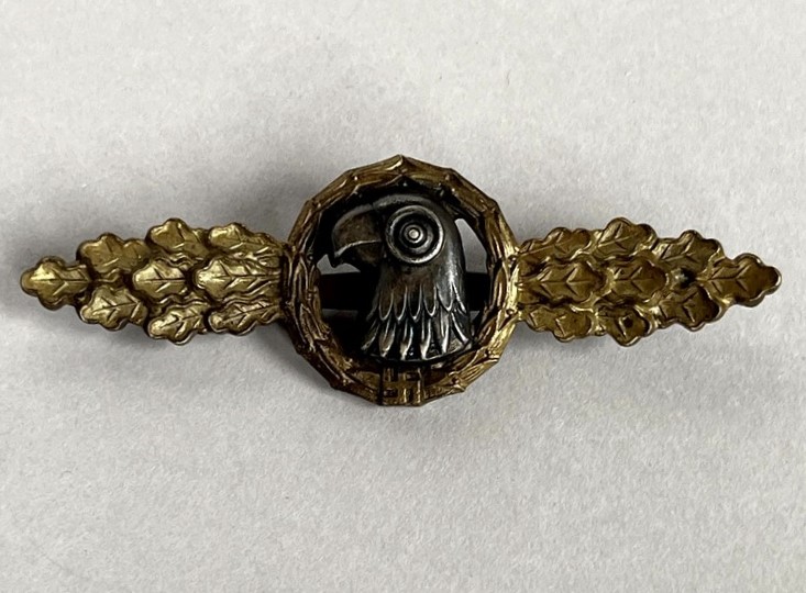 A metal pin with a bird in the center

AI-generated content may be incorrect.