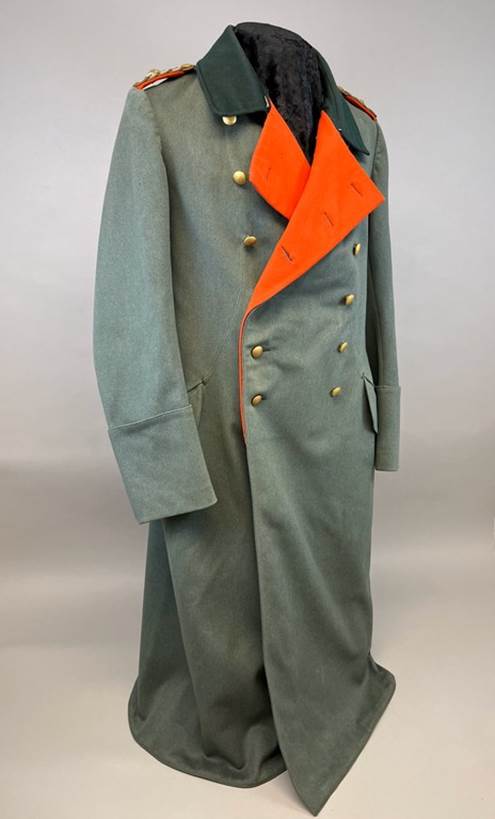 A long green coat with orange sash

AI-generated content may be incorrect.