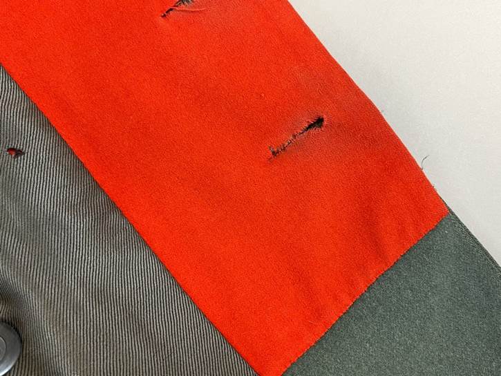 A red and grey fabric with holes

AI-generated content may be incorrect.