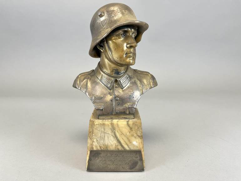 A bronze bust of a person in a helmet

AI-generated content may be incorrect.