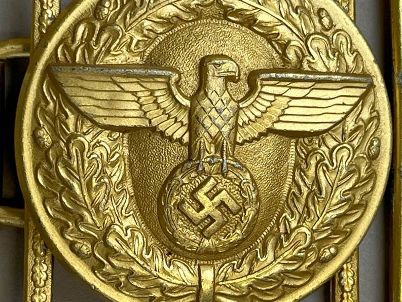 A gold eagle with a swastika and a circle with a swastika and a circle with a symbol

AI-generated content may be incorrect.