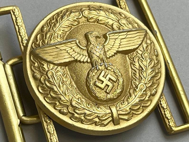 A gold metal object with a symbol

AI-generated content may be incorrect.