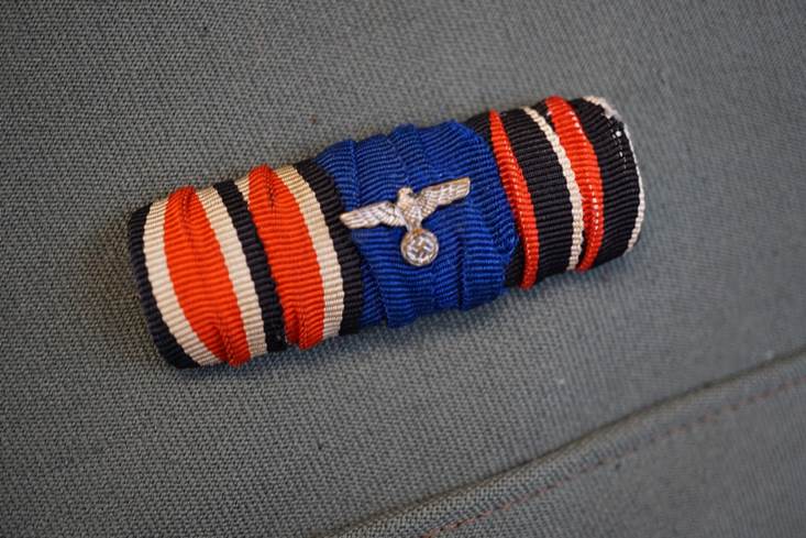 A blue and red ribbon with a small eagle on it

AI-generated content may be incorrect.