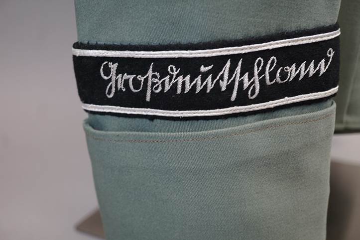 Close-up of a green hat with a black and white patch

AI-generated content may be incorrect.