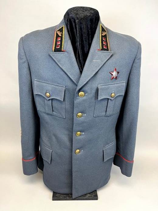 A grey military uniform with a red and black patch

AI-generated content may be incorrect.