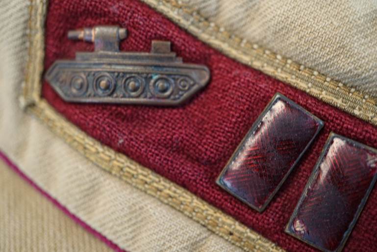 A pair of metal pins on a red and tan fabric

AI-generated content may be incorrect.