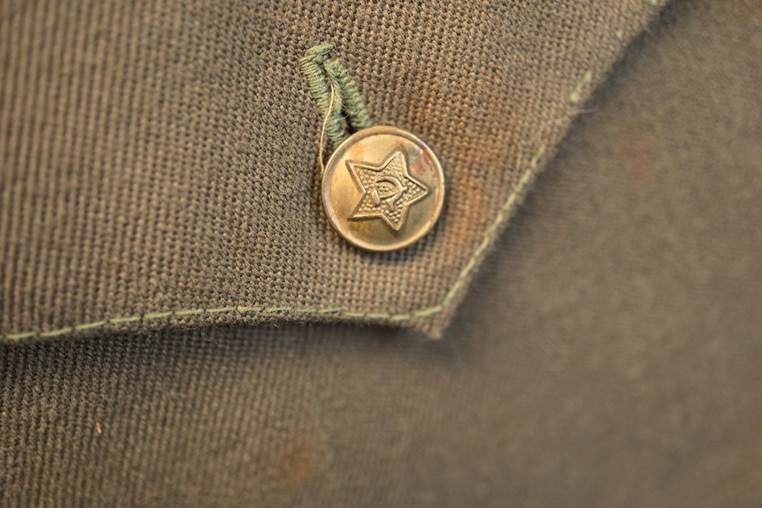 A button on a green shirt

AI-generated content may be incorrect.