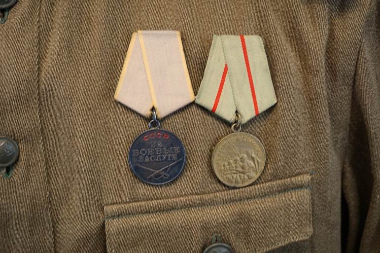 Close-up of medals on a jacket

AI-generated content may be incorrect.