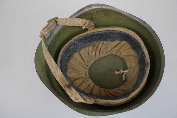 A green helmet with a strap

AI-generated content may be incorrect.