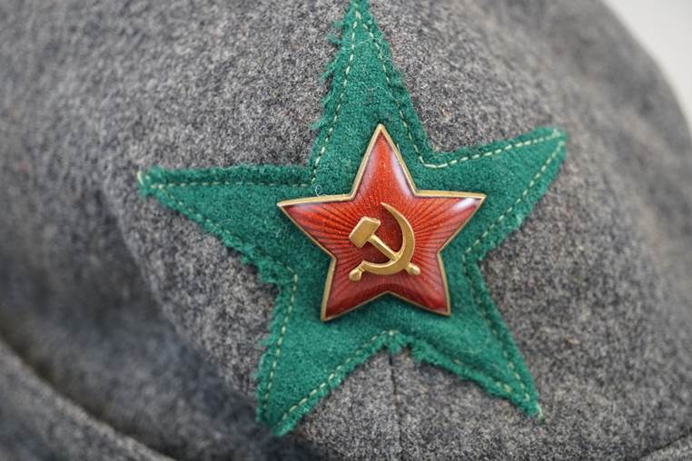 A red star and a hammer and sickle on a gray hat

AI-generated content may be incorrect.