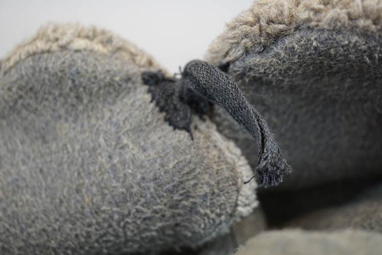 A close-up of a grey fuzzy slippers

AI-generated content may be incorrect.