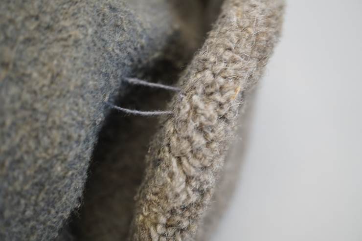 Close-up of a grey knitted fabric

AI-generated content may be incorrect.