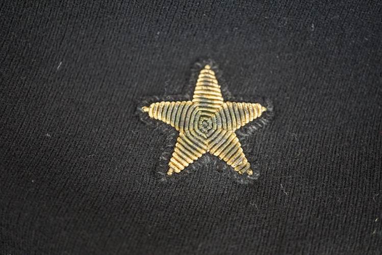 A gold star on a black fabric

AI-generated content may be incorrect.