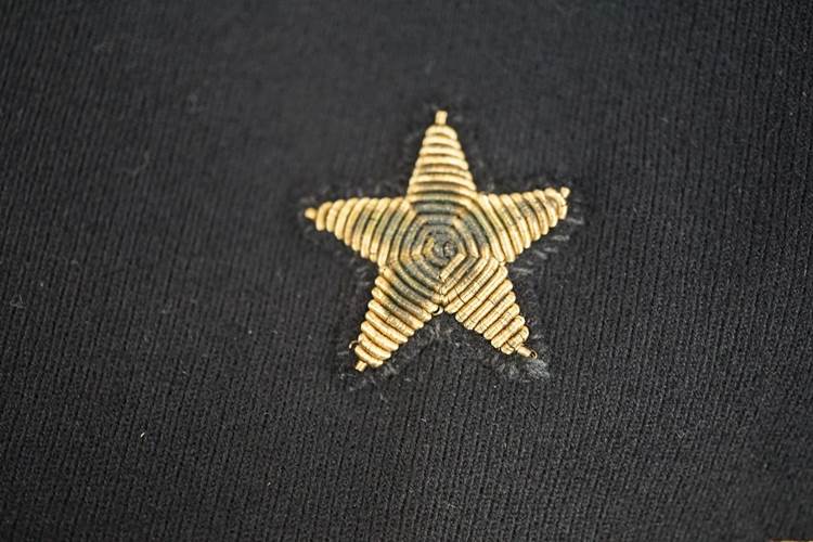 A gold star on a black fabric

AI-generated content may be incorrect.