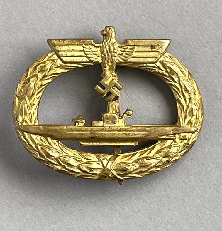 A gold metal badge with a ship in the middle

AI-generated content may be incorrect.