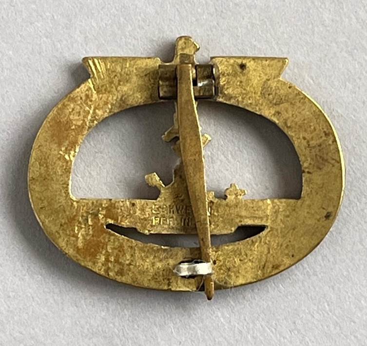 A gold metal object with a boat and a boat on it

AI-generated content may be incorrect.