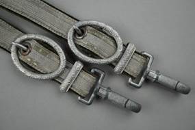 A pair of grey straps with metal rings

Description automatically generated