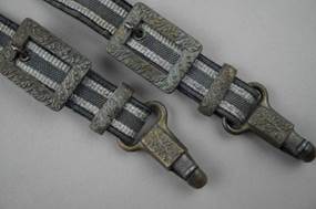A pair of metal straps

Description automatically generated