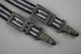 A pair of straps with metal clasps

Description automatically generated