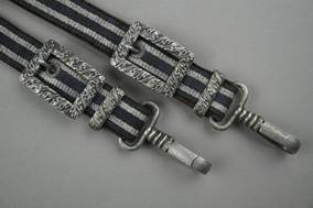 A pair of belts with metal buckles

Description automatically generated