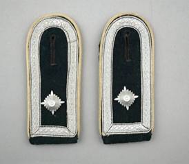 A pair of black and white military uniform shoulder pads

Description automatically generated
