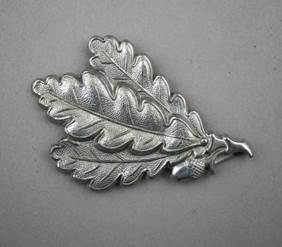 A silver leaf shaped object

Description automatically generated