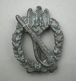 A metal badge with an object and a wreath

Description automatically generated