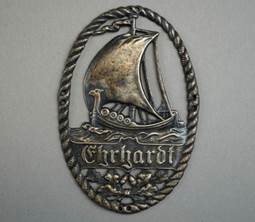 A metal plaque with a boat and text

Description automatically generated