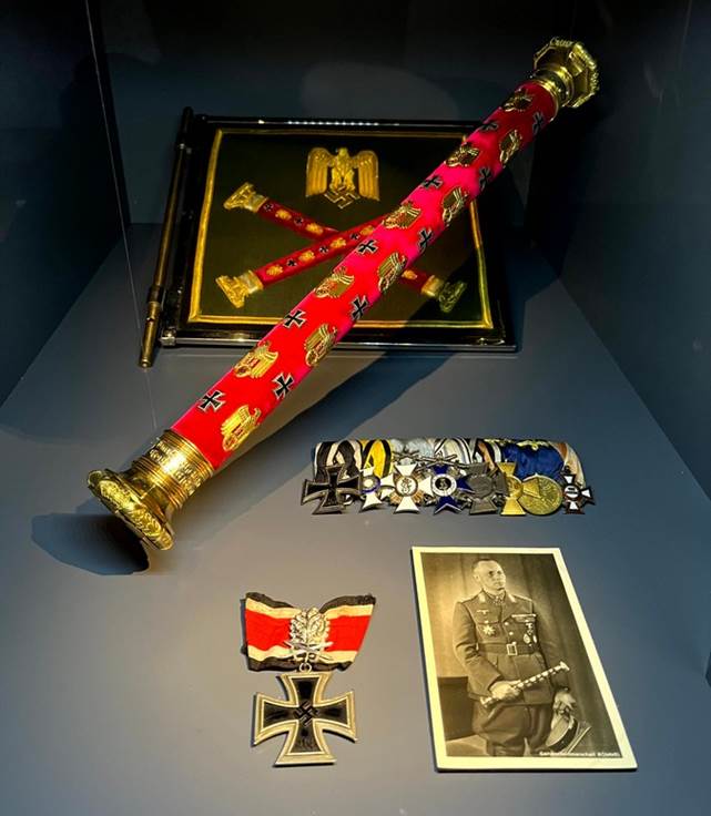 A display case with medals and a red and gold object

AI-generated content may be incorrect.