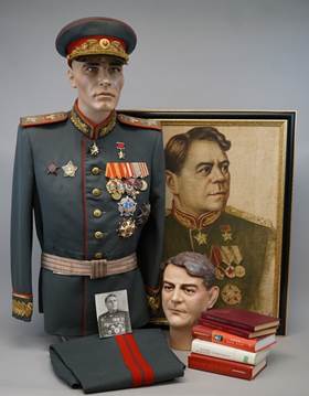 A mannequin in a uniform next to a picture of a person

Description automatically generated