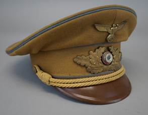 A brown hat with a gold emblem

Description automatically generated