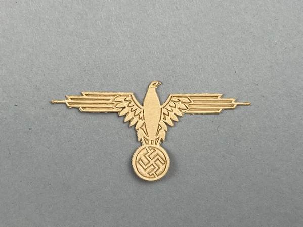 A gold eagle with a circle and a symbol

AI-generated content may be incorrect.